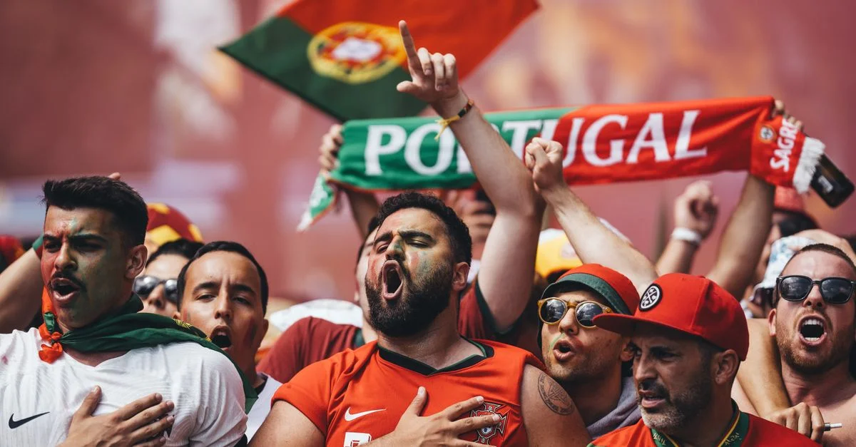 Supporters passionnés du Portugal célébrant avec des drapeaux et des écharpes dans une célébration vibrante.