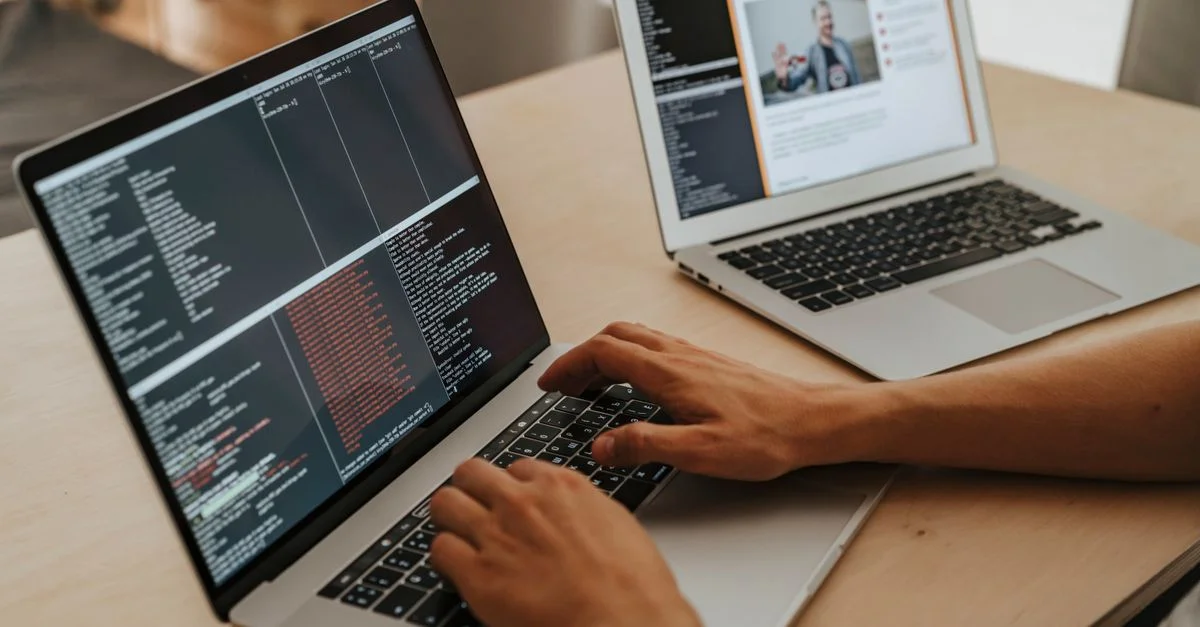 Un développeur travaillant sur un ordinateur portable, tapant du code, mettant en valeur ses compétences en programmation et en technologie.