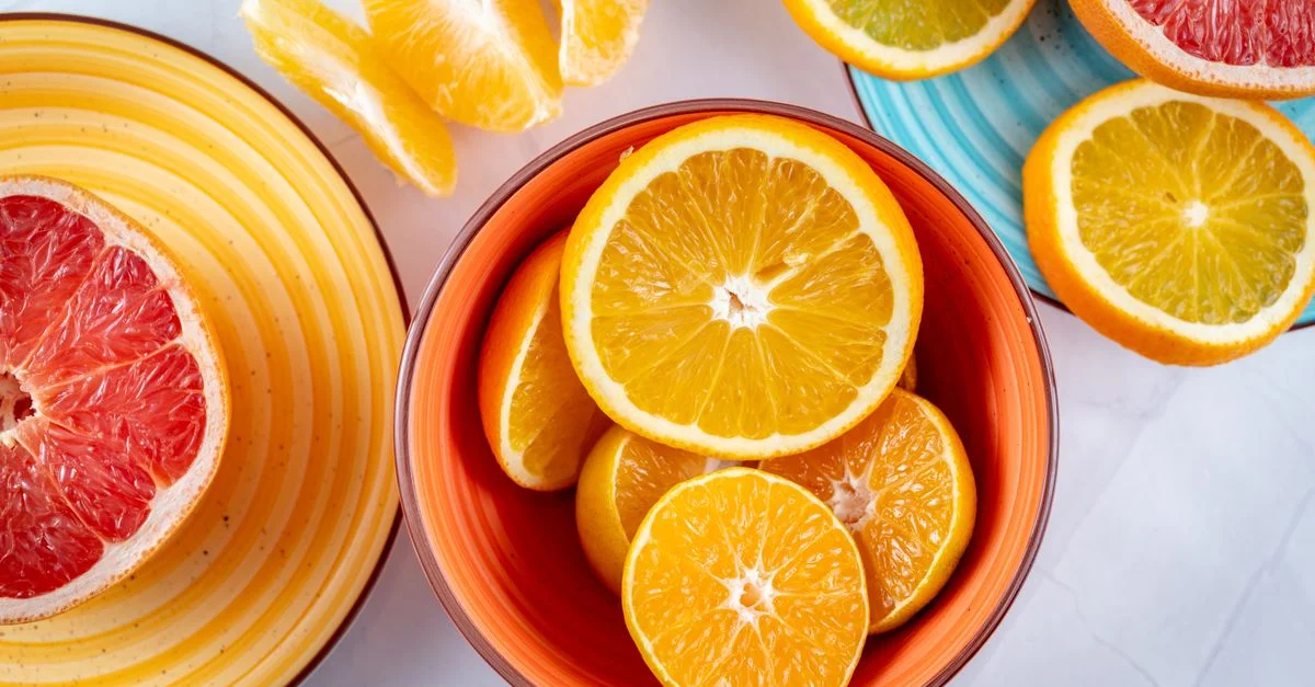 Tranches d'agrumes disposées de manière créative dans des bols en céramique, mettant en avant une présentation vive et fraîche de pamplemousses et d'oranges.
