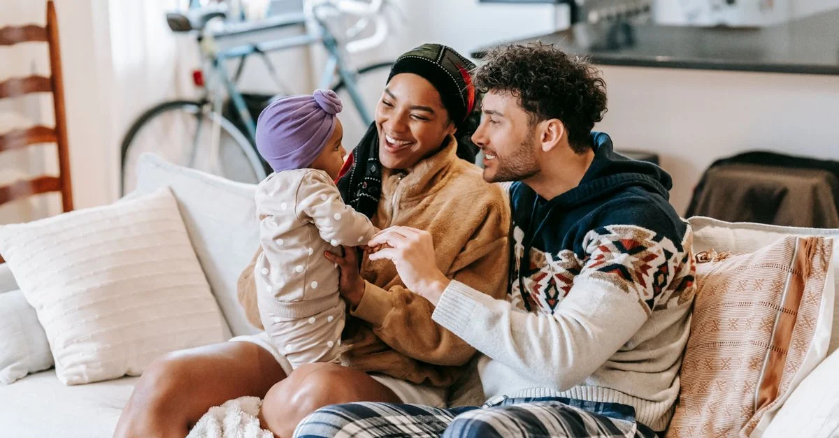 Une famille joyeuse partage des moments de bonheur sur le canapé à l’intérieur, créant des souvenirs durables.