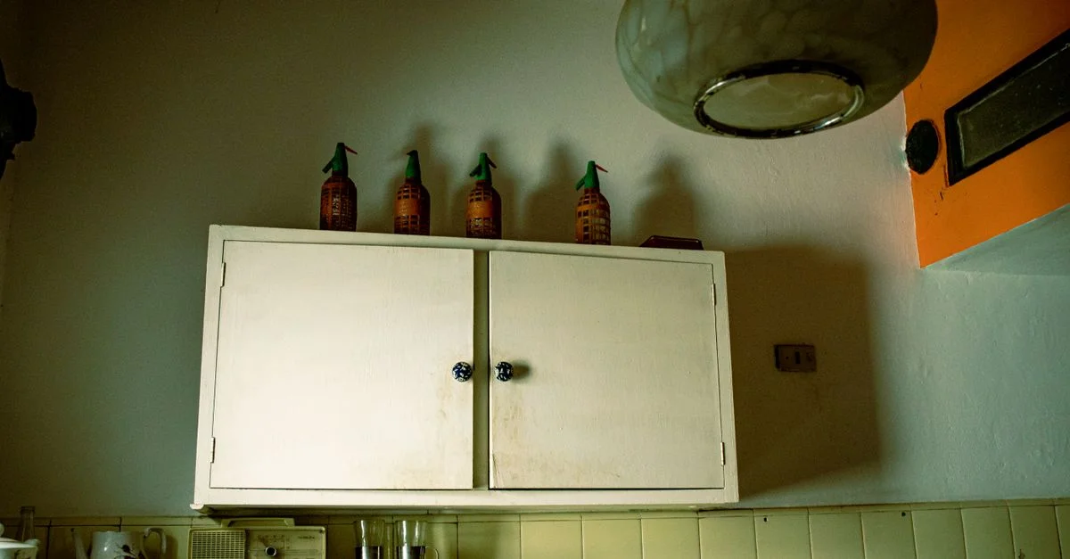 Capture d'une cuisine rétro présentant un vieux placard et des éléments de décor vintage sous un éclairage doux.
