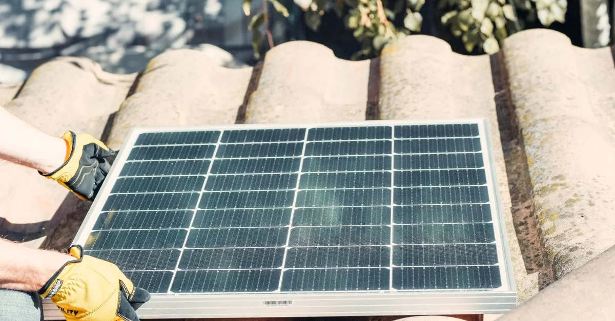Technicien installant un panneau solaire sur le toit au soleil. Installation d'énergie renouvelable.
