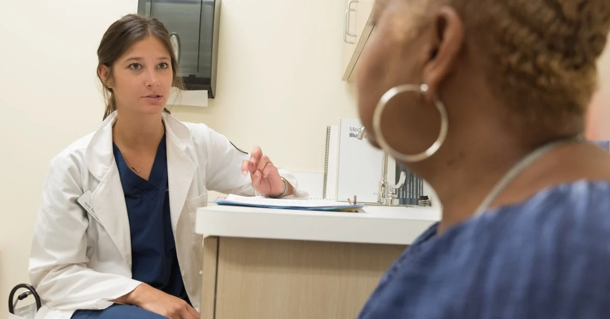 Médecin en consultation avec un patient dans une clinique médicale, discutant des options de traitement.