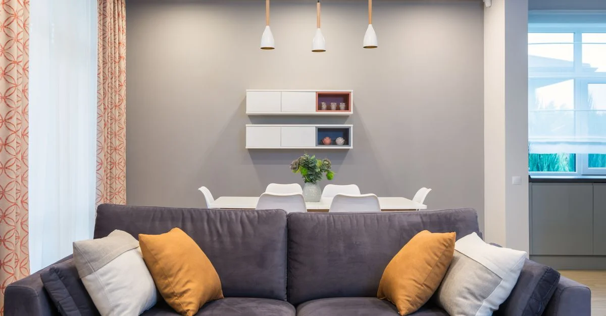 Salon contemporain avec un canapé confortable, une décoration élégante et un éclairage d'ambiance.
