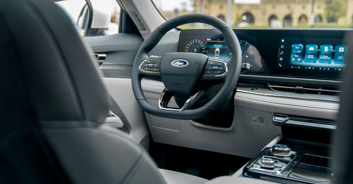 Intérieur de voiture moderne élégant avec tableau de bord numérique et éléments de design luxueux.