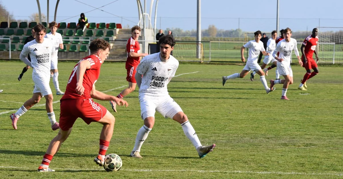 Match de football de jeunes passionnant à Tarpa, en Hongrie, avec des joueurs en action par une journée ensoleillée.