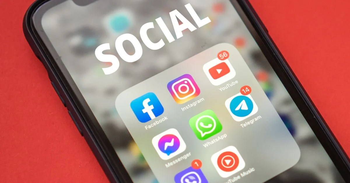 Gros plan sur un smartphone affichant des applications de réseaux sociaux populaires.