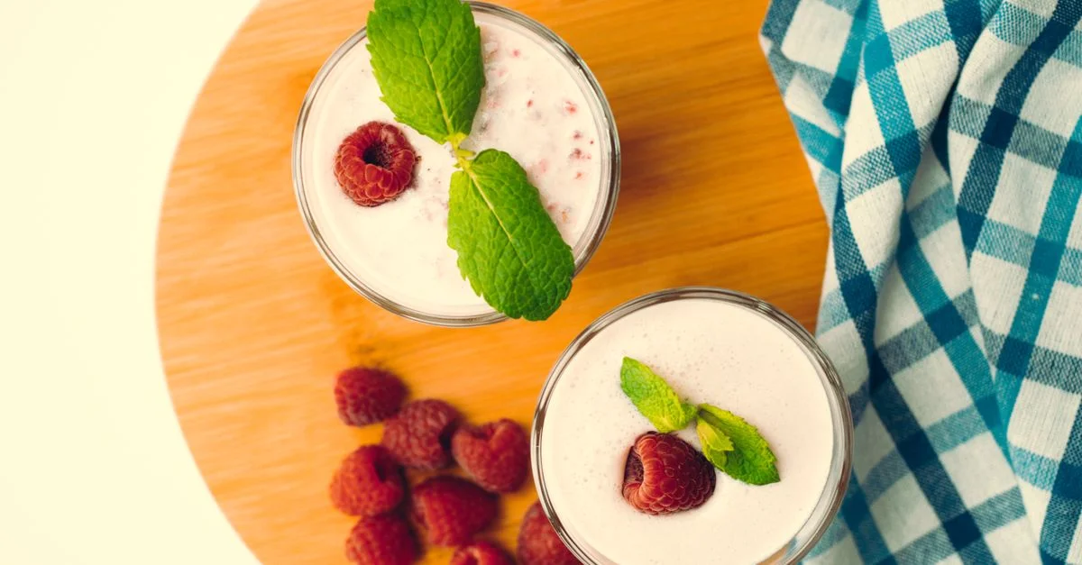 Vue de dessus de smoothies à la framboise avec des feuilles de menthe sur une planche en bois, une parfaite rafraîchissante d'été.