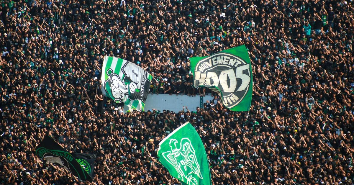 Une foule énergique agitant des drapeaux lors d'un match de football du Raja Casablanca au Maroc.