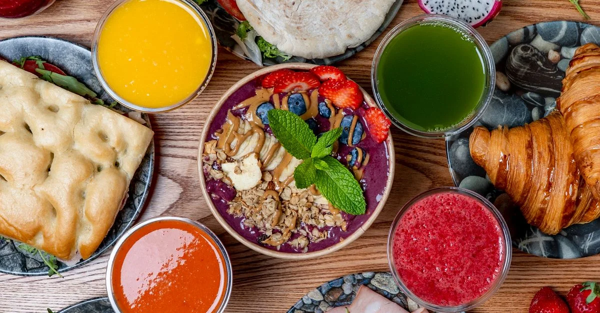 Un petit-déjeuner dynamique composé de smoothies, de viennoiseries et de fruits frais. Idéal pour bien commencer la journée.